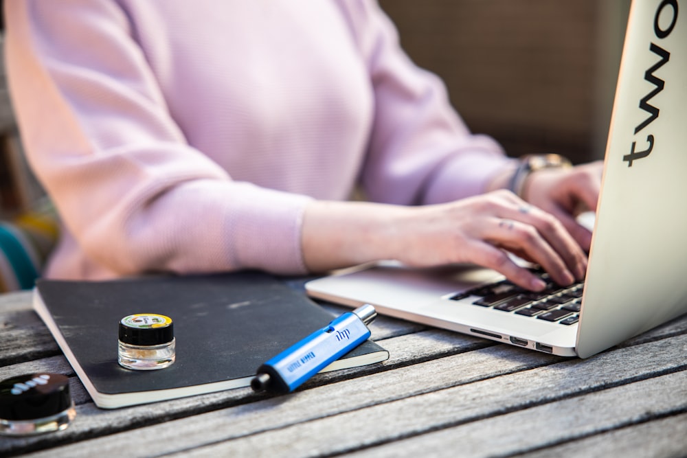 a woman sitting at a table using a laptop computer