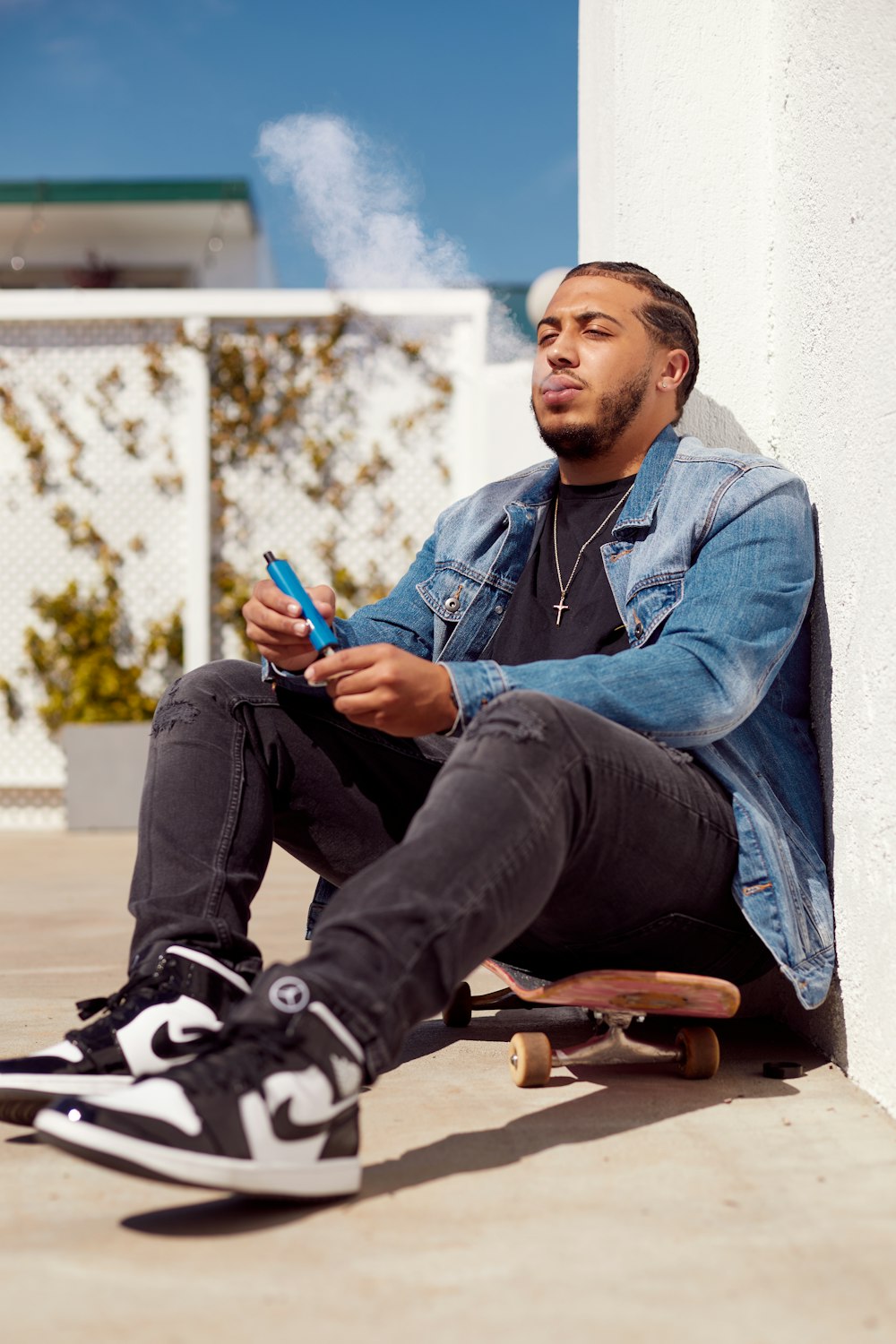 a man sitting on a skateboard next to a building