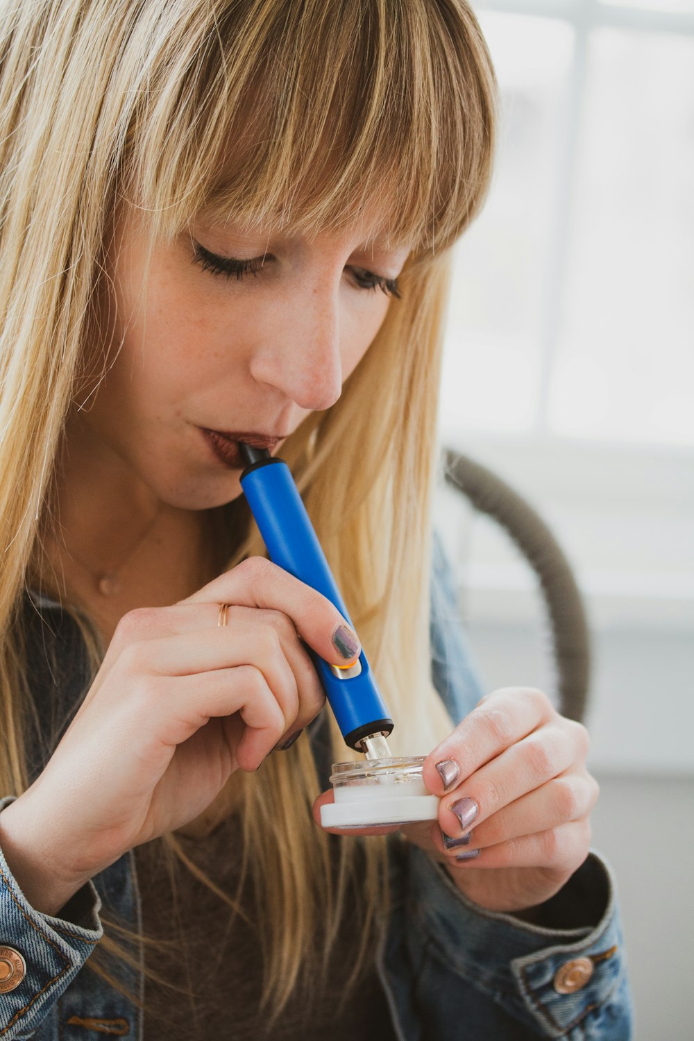 a woman holding a blue toothbrush in her mouth
