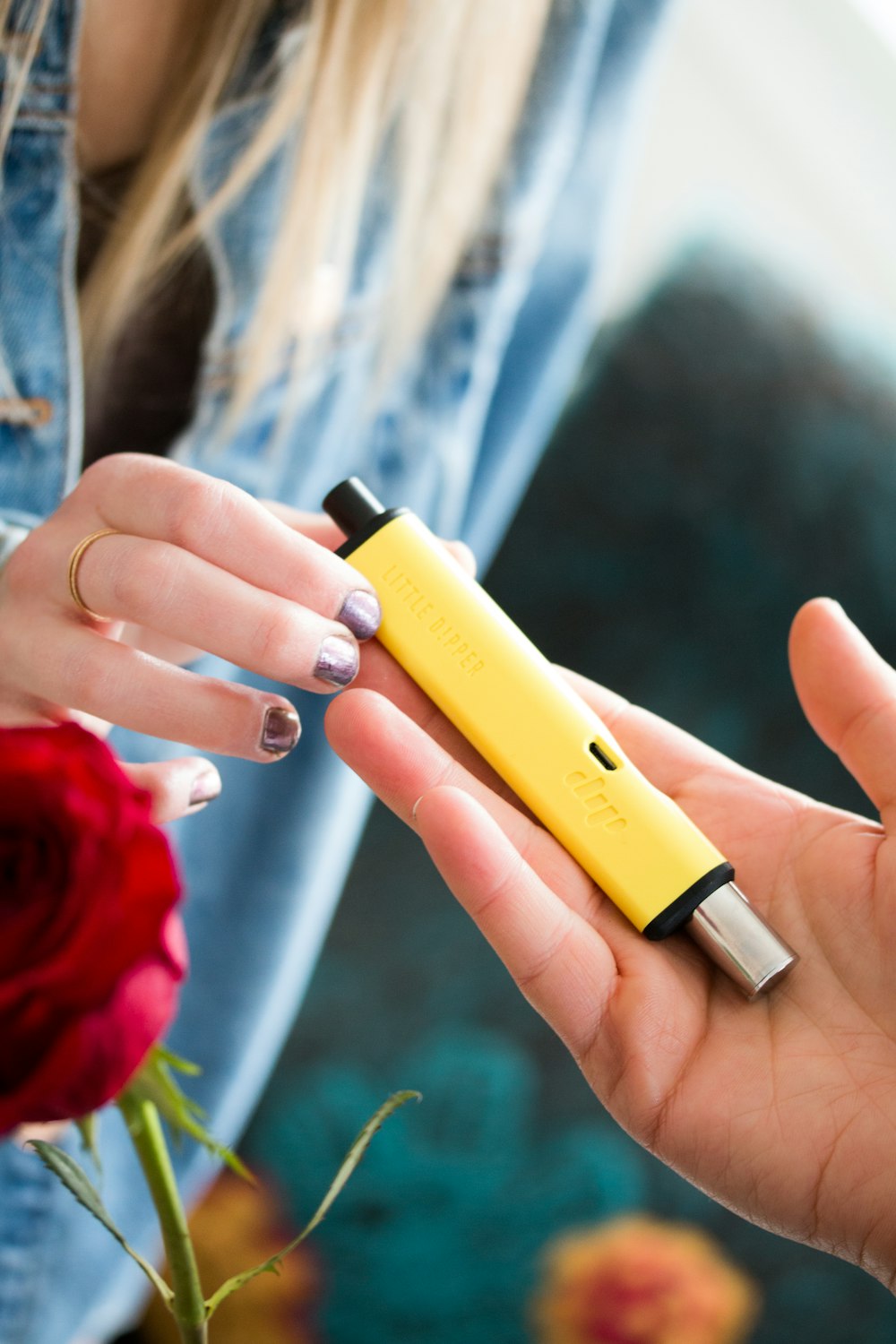 a woman holding a yellow lighter in her hand