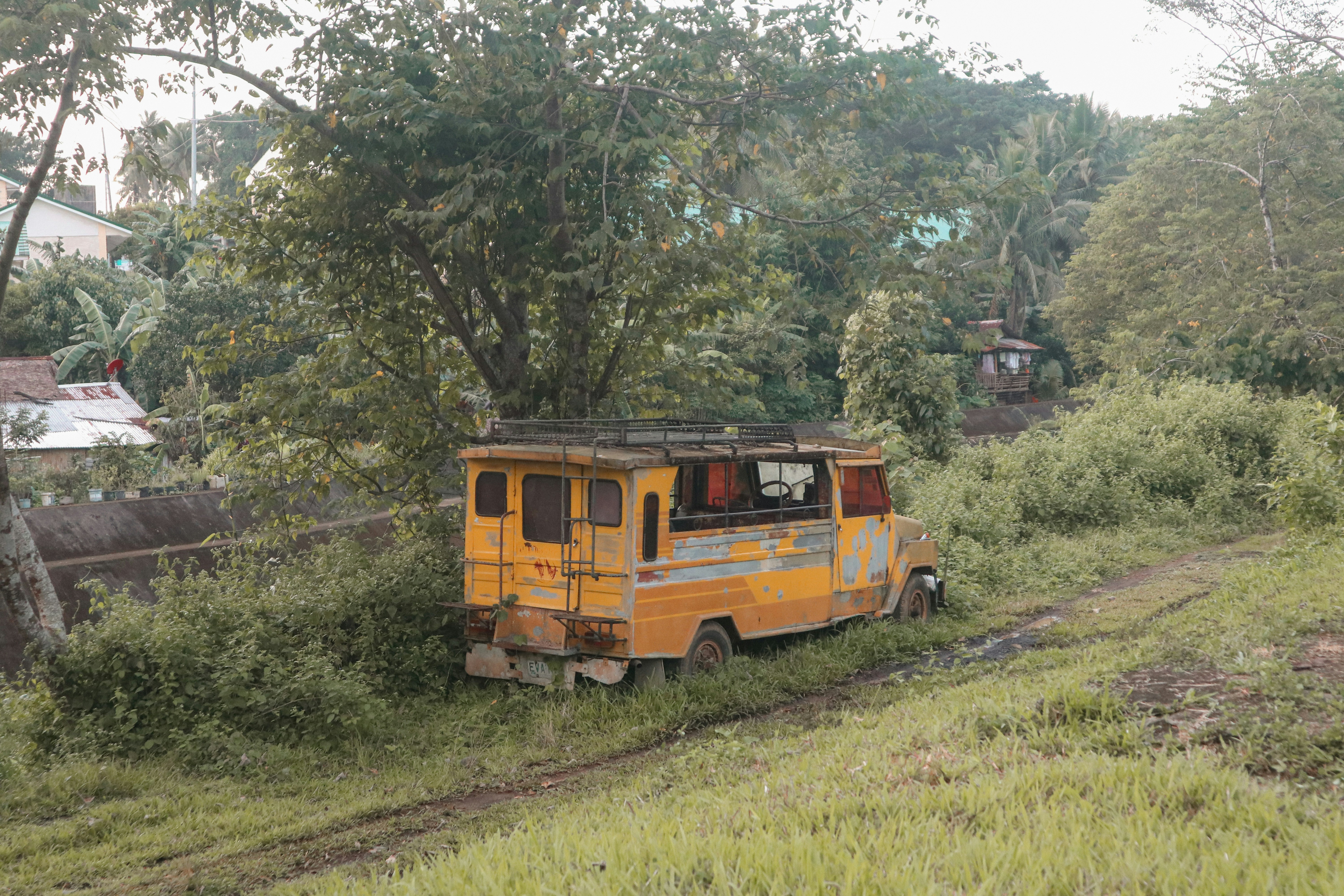 an old yellow truck is parked in a field