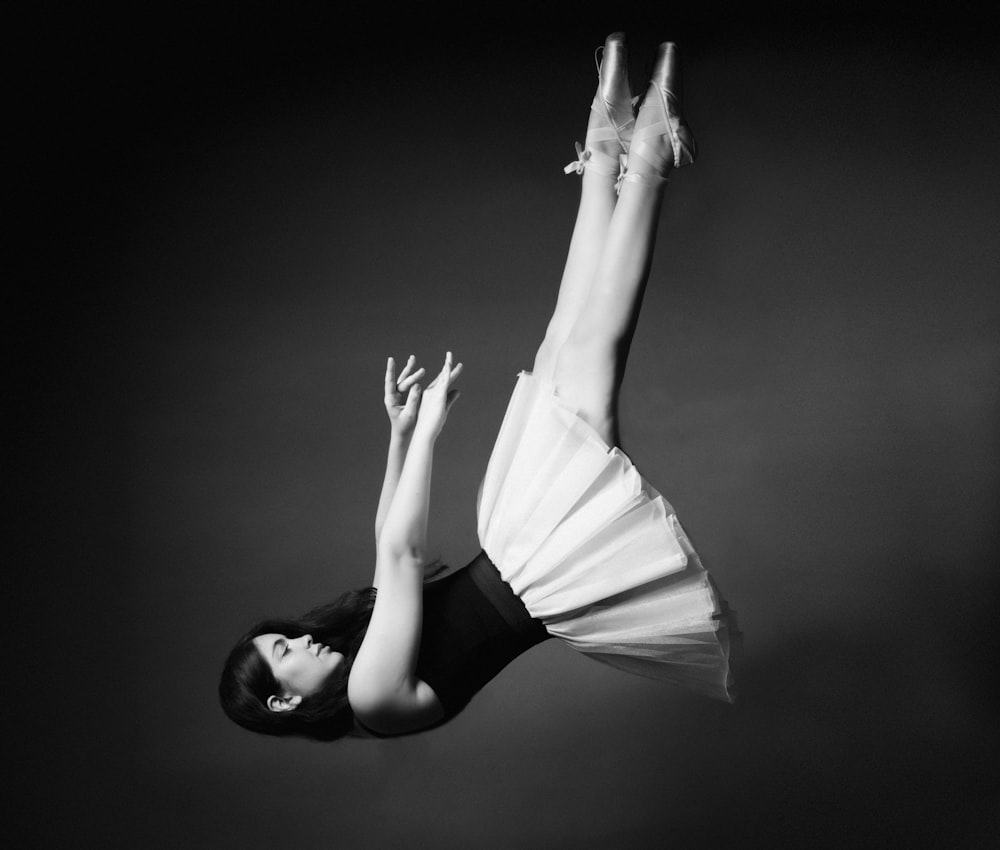 a black and white photo of a woman doing a handstand