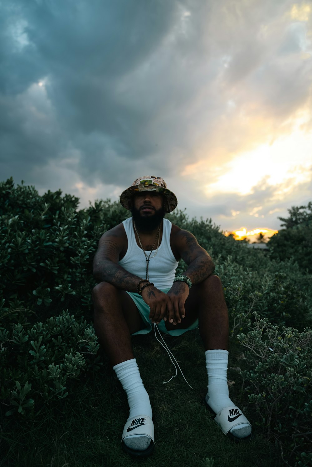 a man with a beard sitting in a field