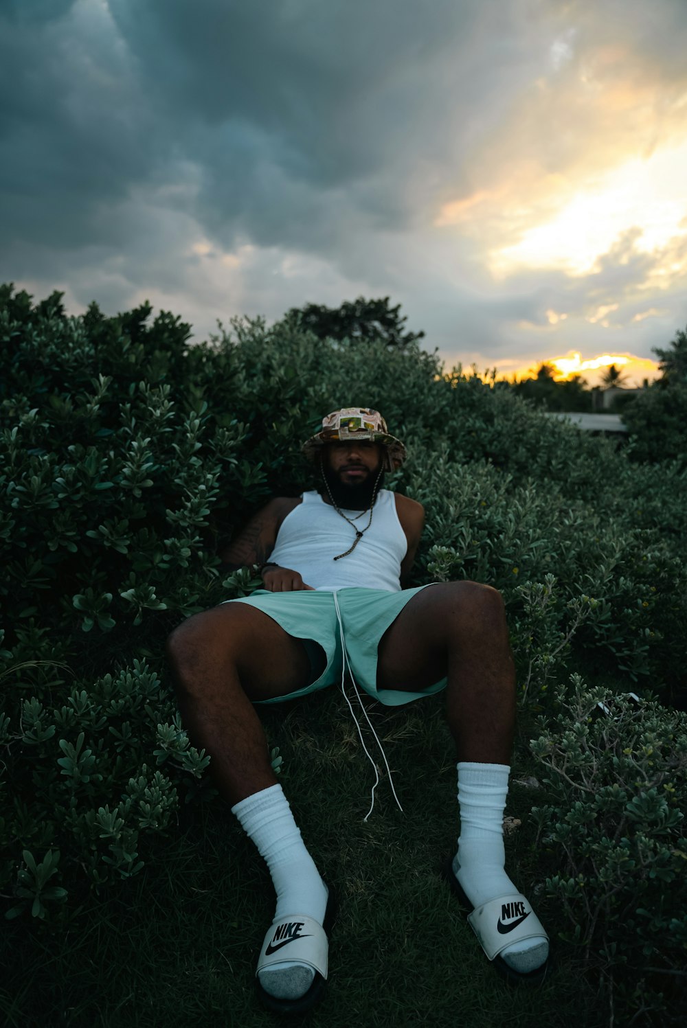 a man sitting in the grass with his legs crossed