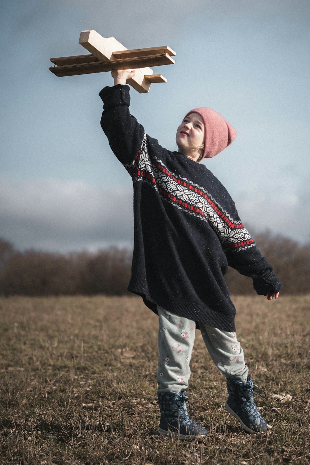 a woman holding a wooden object in the air