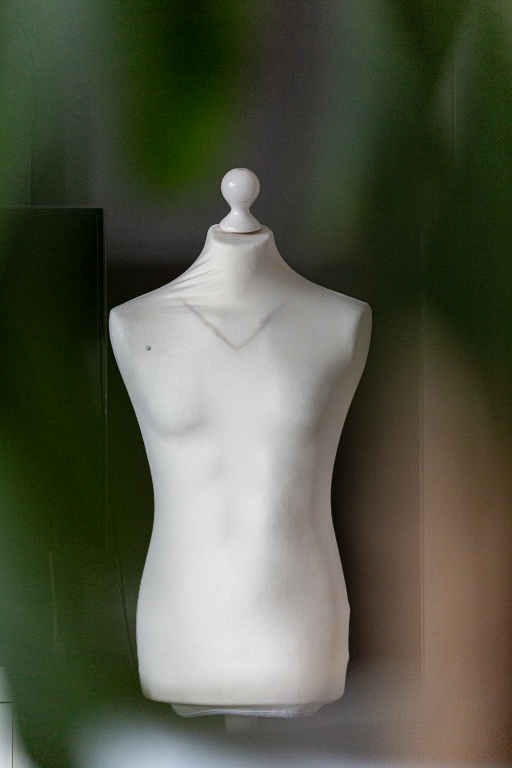 a white mannequin with a white top on display