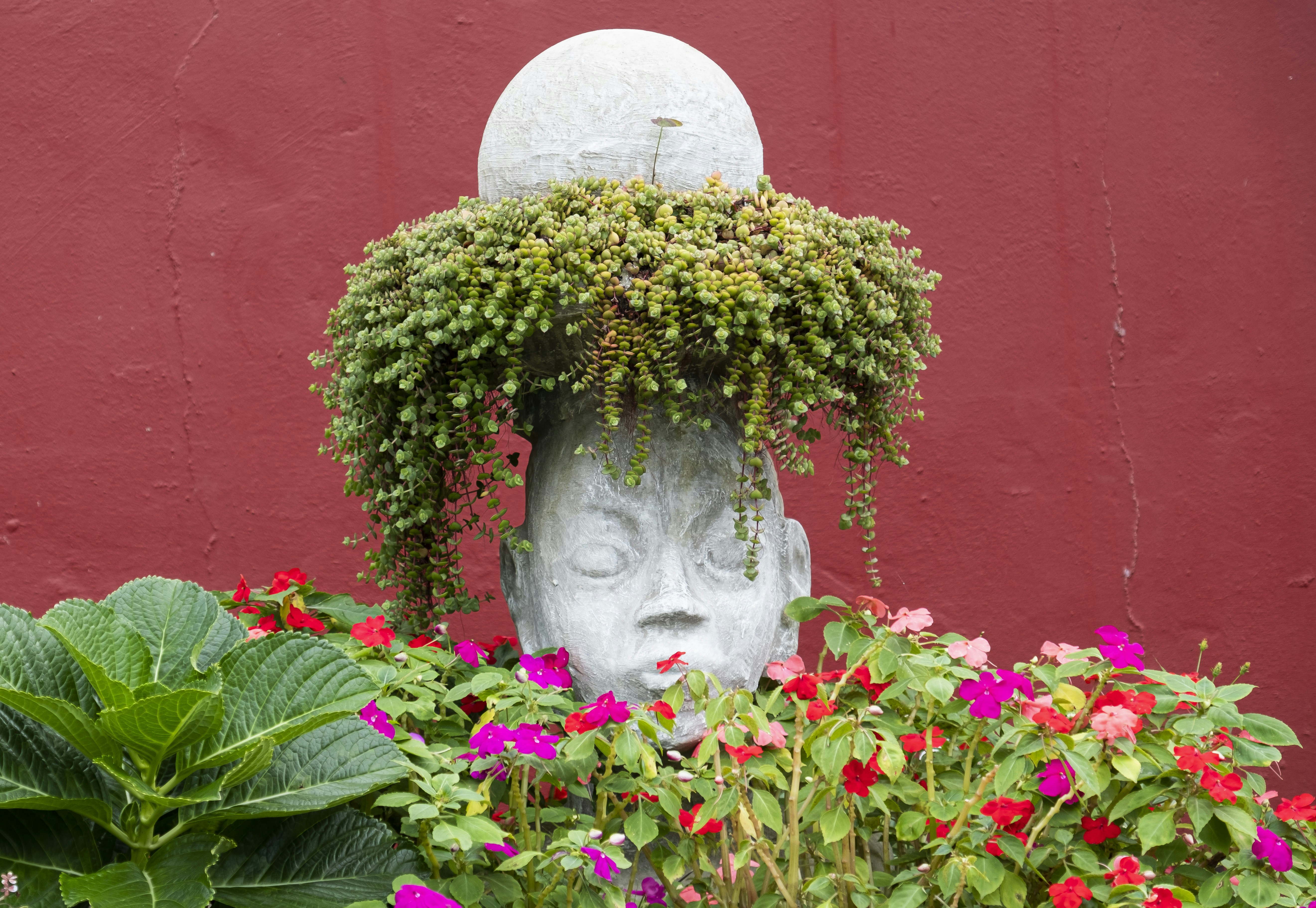 a statue of a head surrounded by flowers