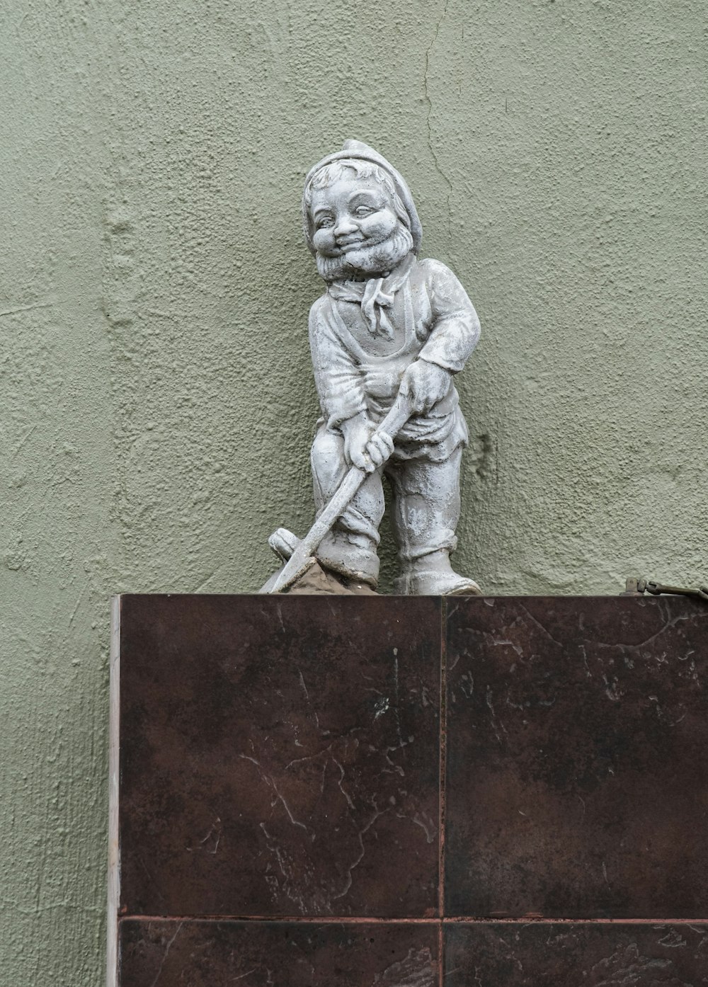 a statue of a boy holding a baseball bat