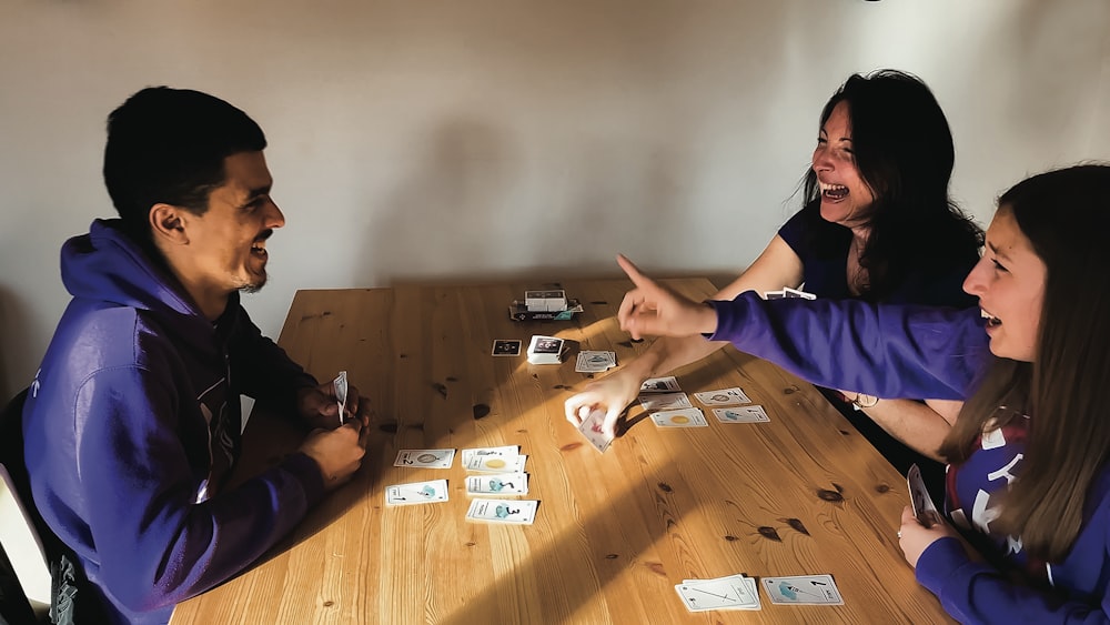 a group of people sitting around a wooden table