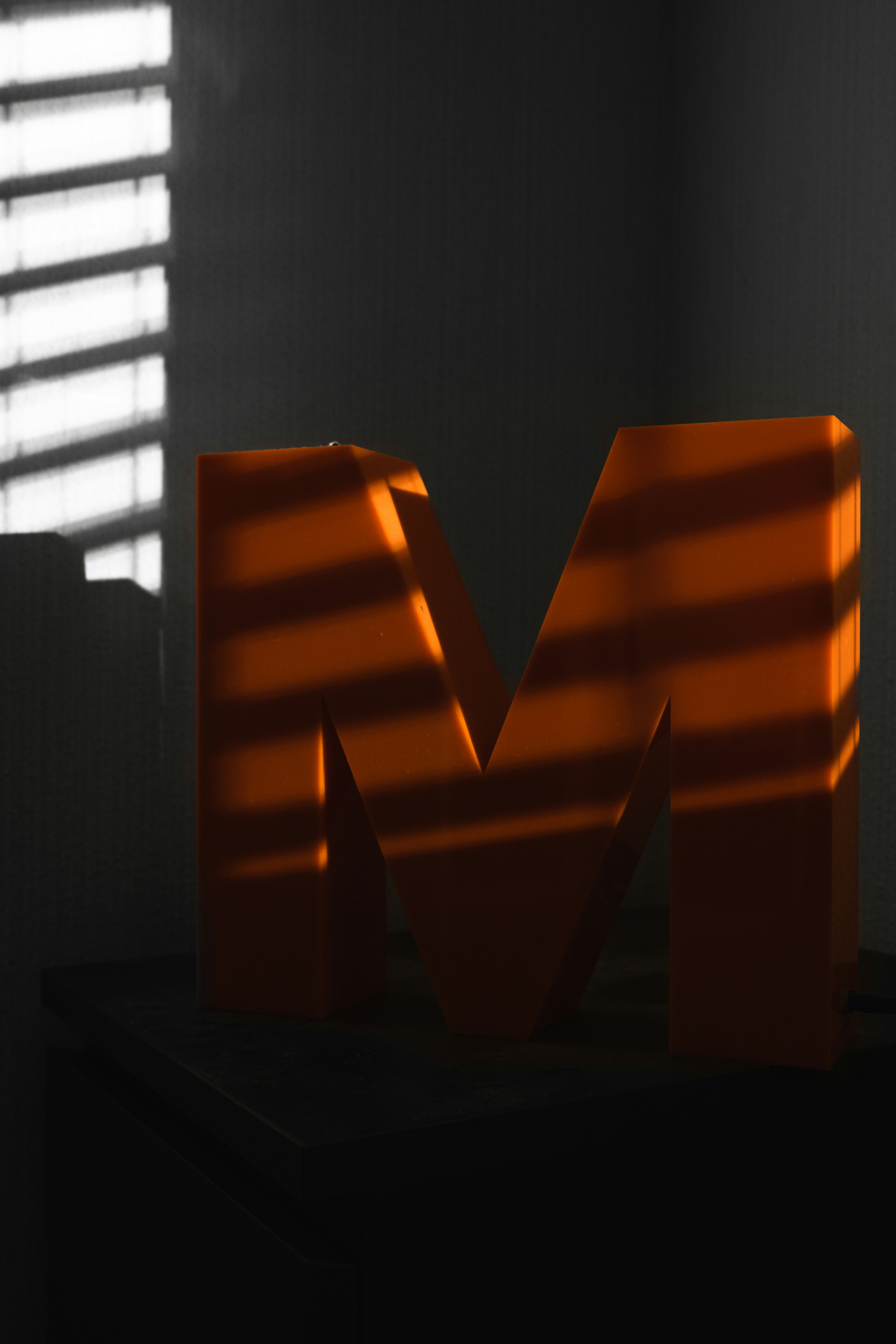 a shadow of the letter m on a table