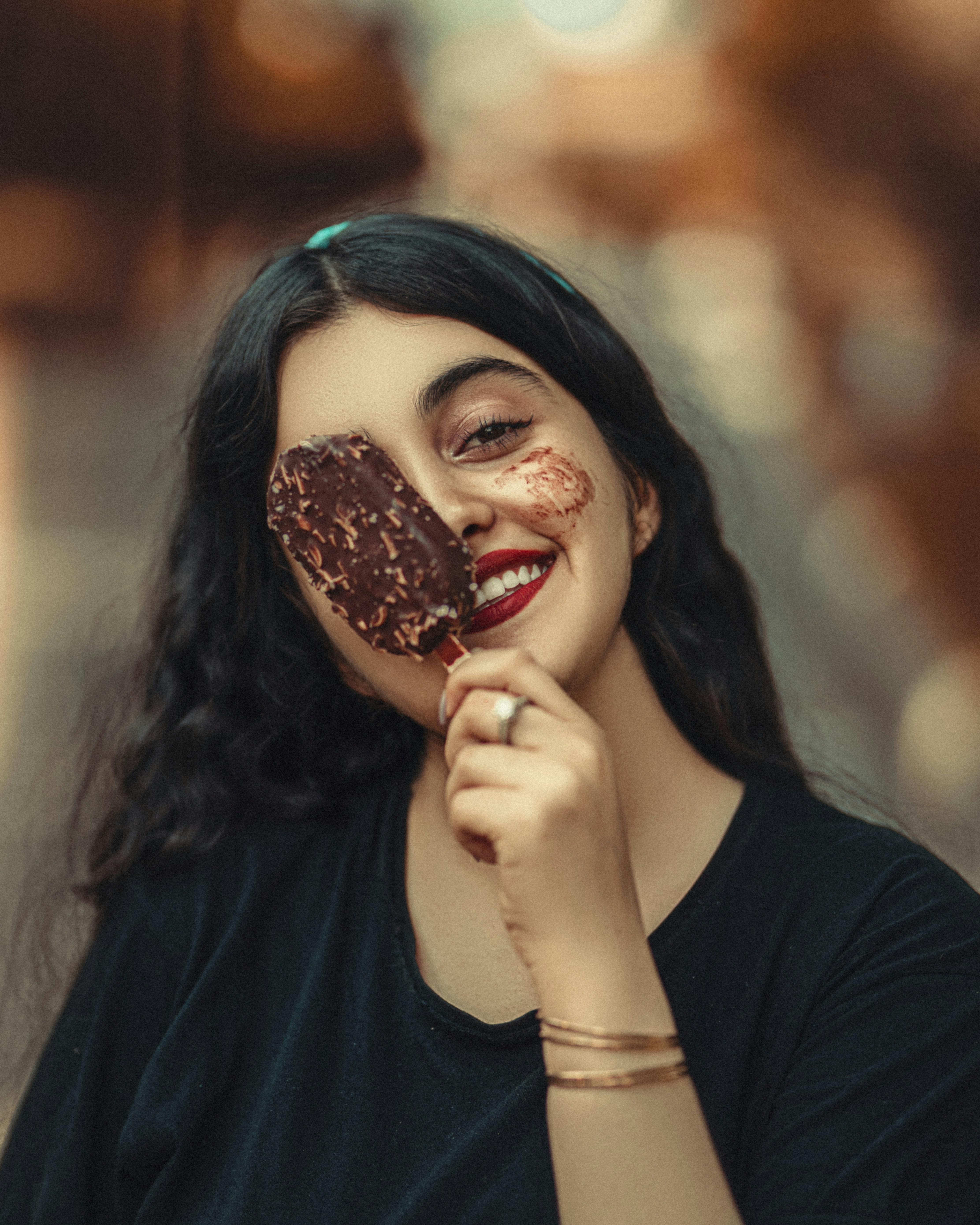a woman holding a piece of chocolate in front of her face