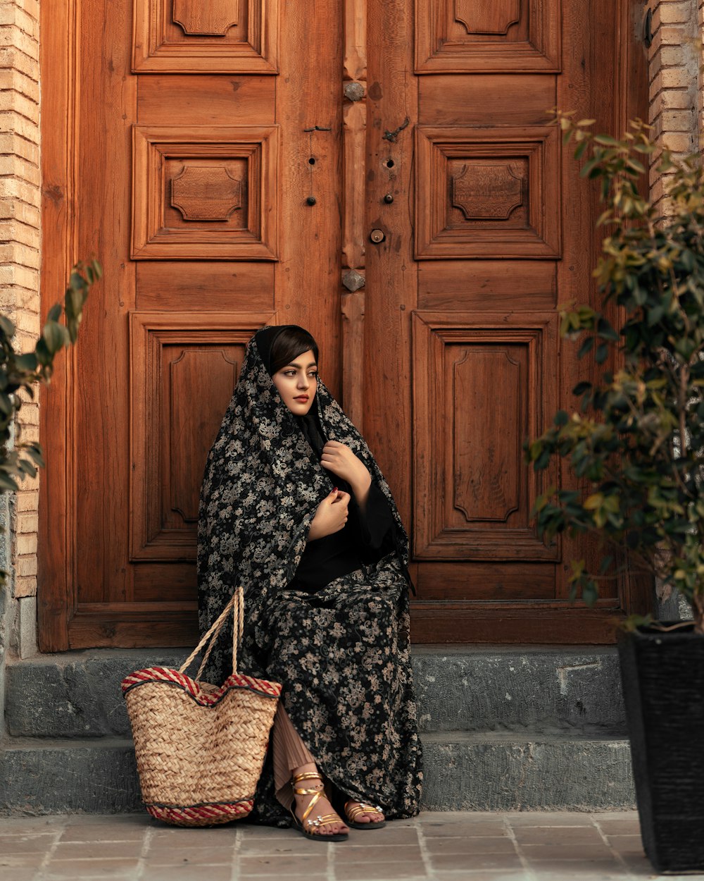 a woman sitting on the steps with a basket