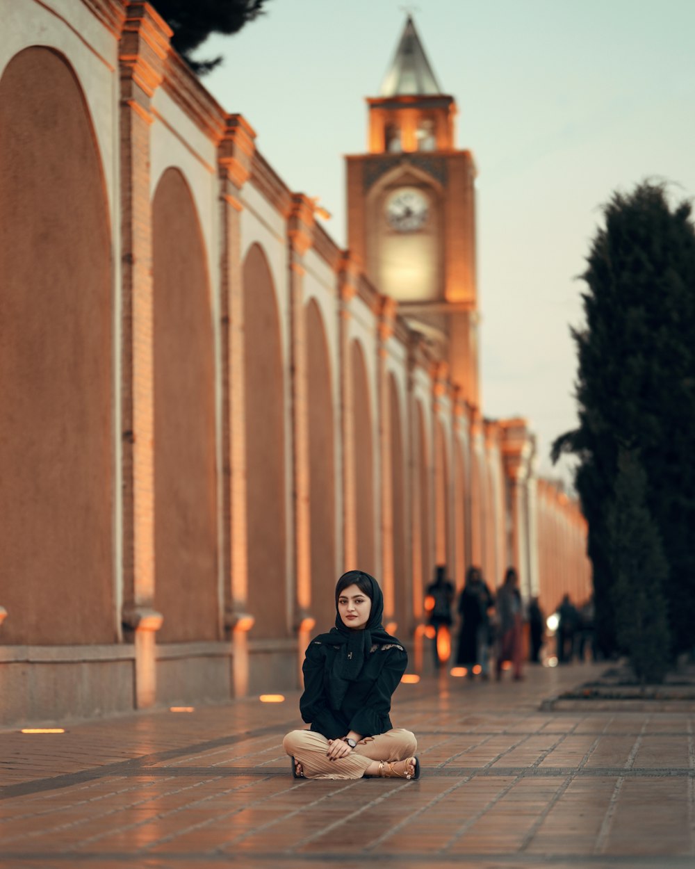 a woman sitting on the ground in front of a building