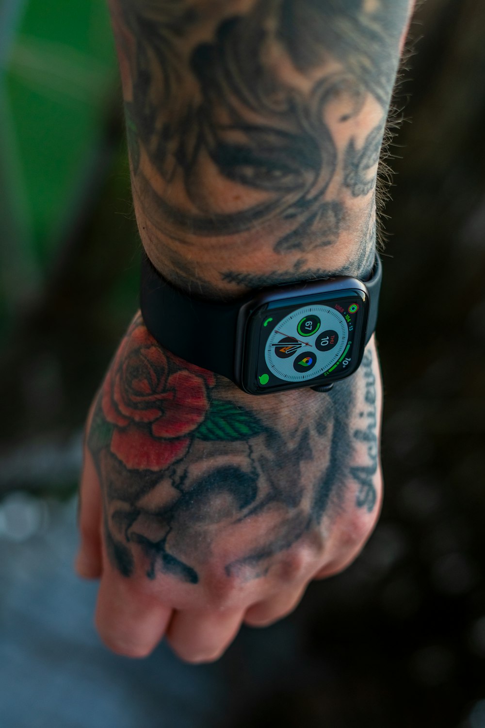 Un homme tatoué sur le bras tenant un téléphone portable