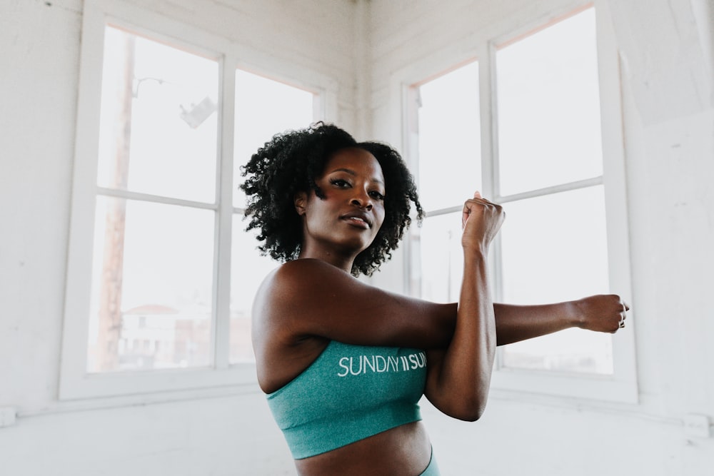 a woman in a sports bra top stretching her arms