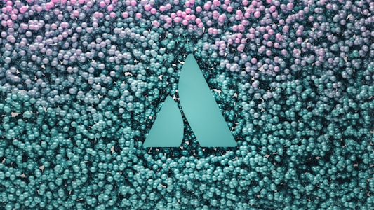 A geometric logo with two triangular shapes is embedded in a backdrop of numerous small spherical objects that transition from teal at the bottom to pink at the top.