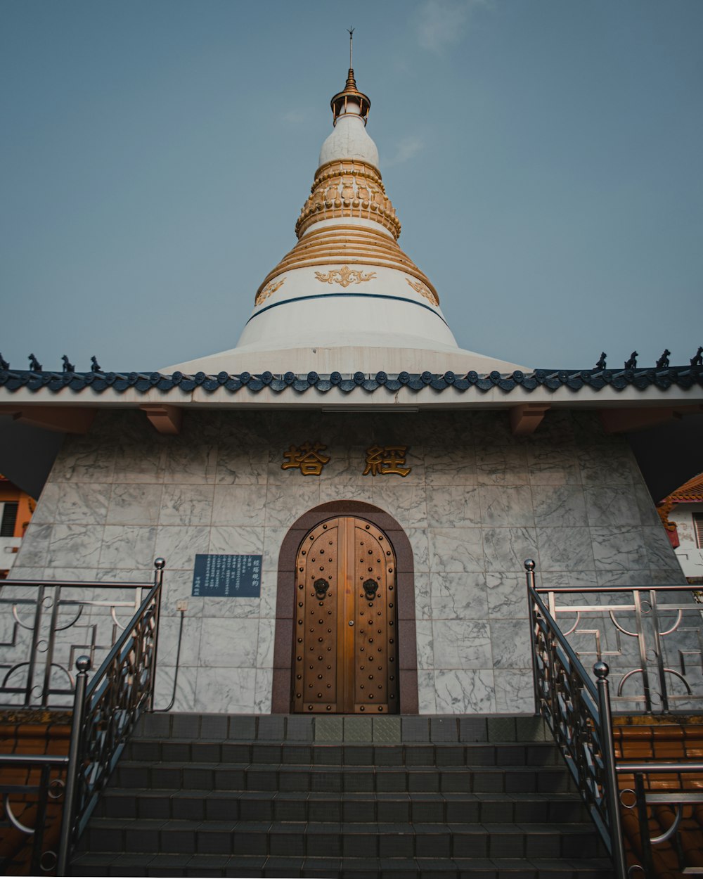 a white and gold building with stairs leading up to it