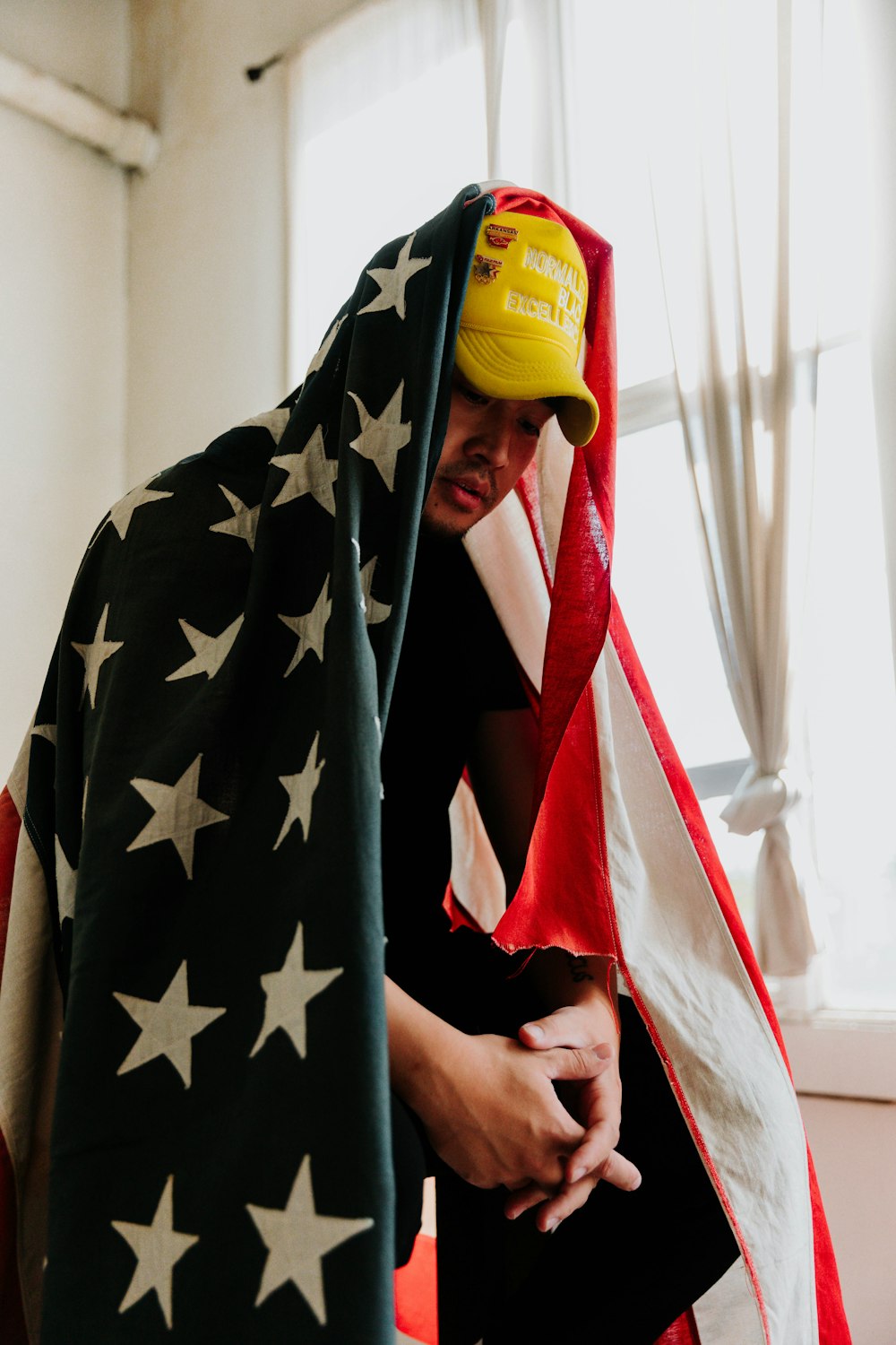 a man with a hat and a flag draped over his head