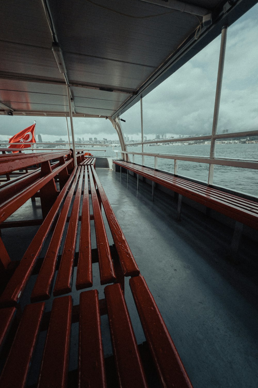 a row of red benches sitting on top of a boat