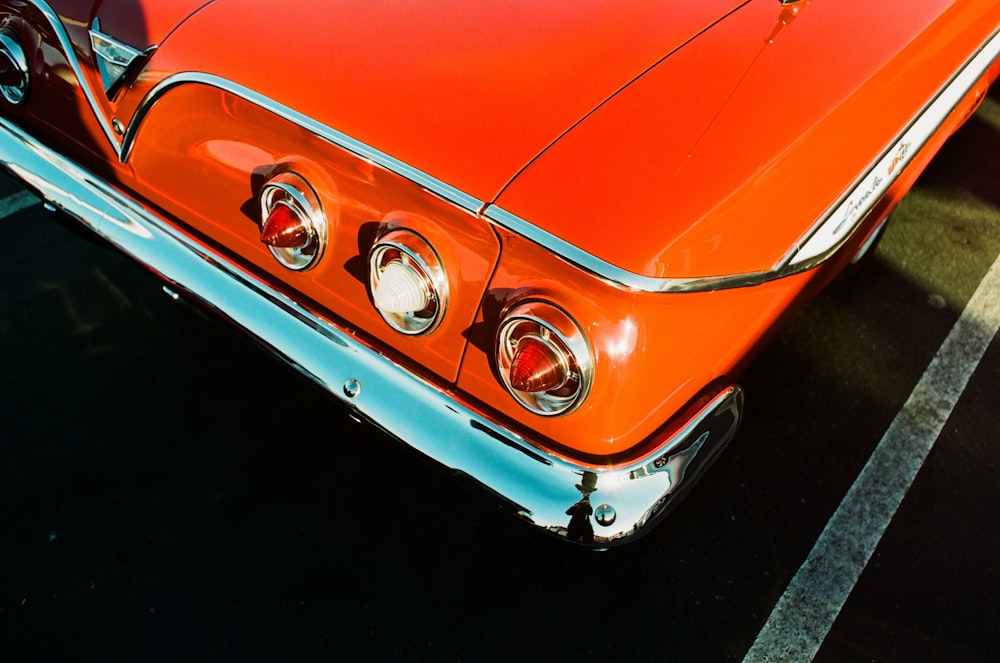 an orange car parked in a parking lot