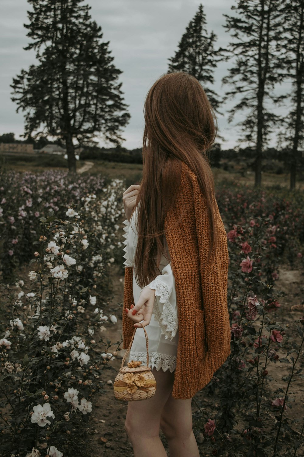 a woman standing in a field of flowers