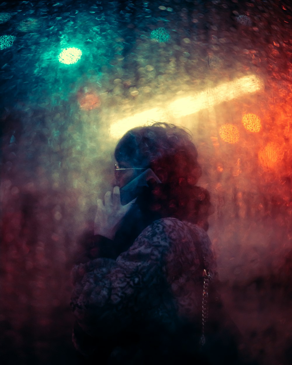 a person standing in the rain talking on a cell phone