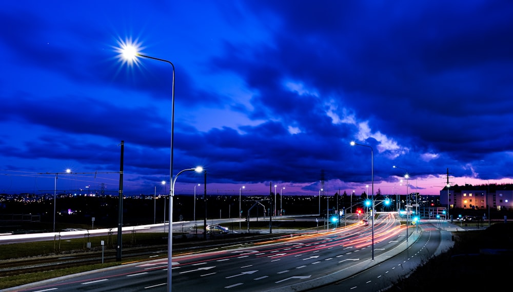 a city street filled with lots of traffic under a cloudy sky