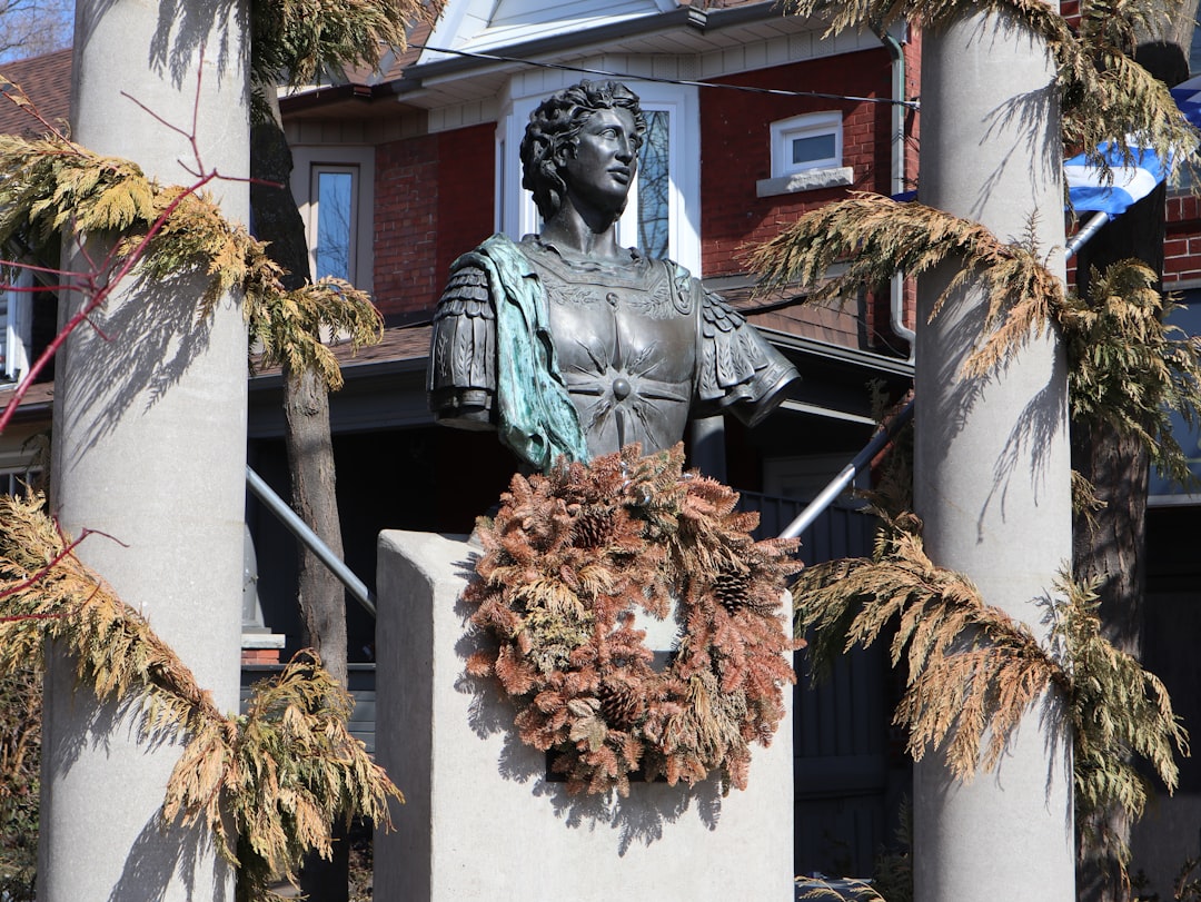 a statue of a woman with a wreath around her neck, A bronze bust of Alexander The Great sits on a stage situated at the 