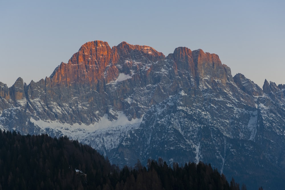 Una cadena montañosa con montañas cubiertas de nieve al fondo