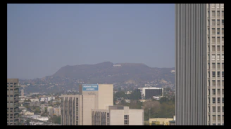 Close-up of hands signing legal documents with a city skyline in the background.