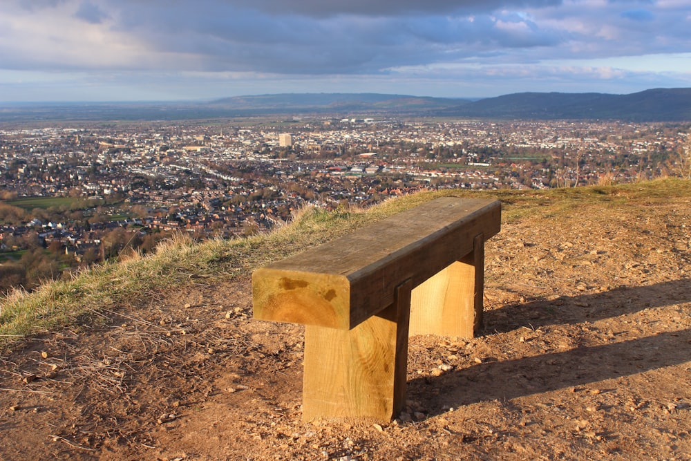 a wooden bench sitting on top of a hill