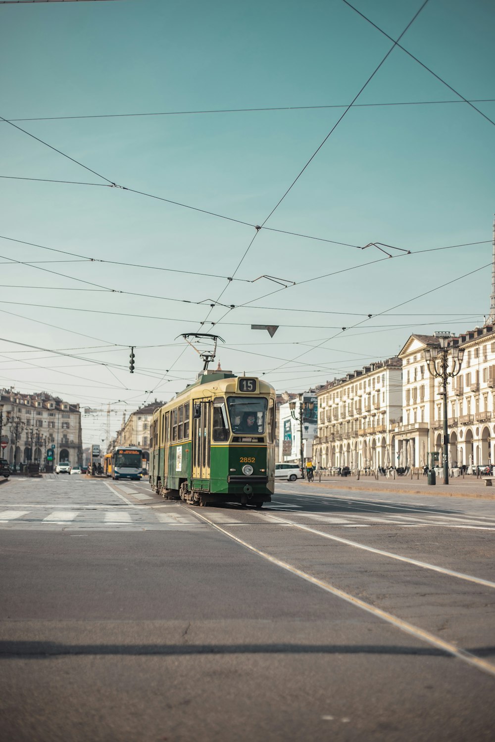 a green and yellow bus driving down a street