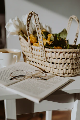 Elegant reading glasses placed beside an open book and a cup of coffee