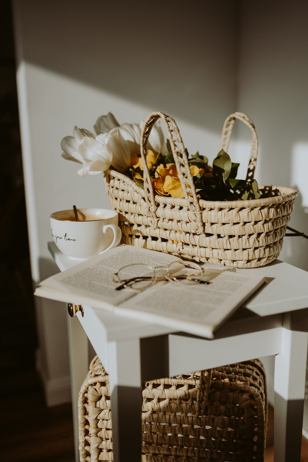 a table with a basket of flowers and a book