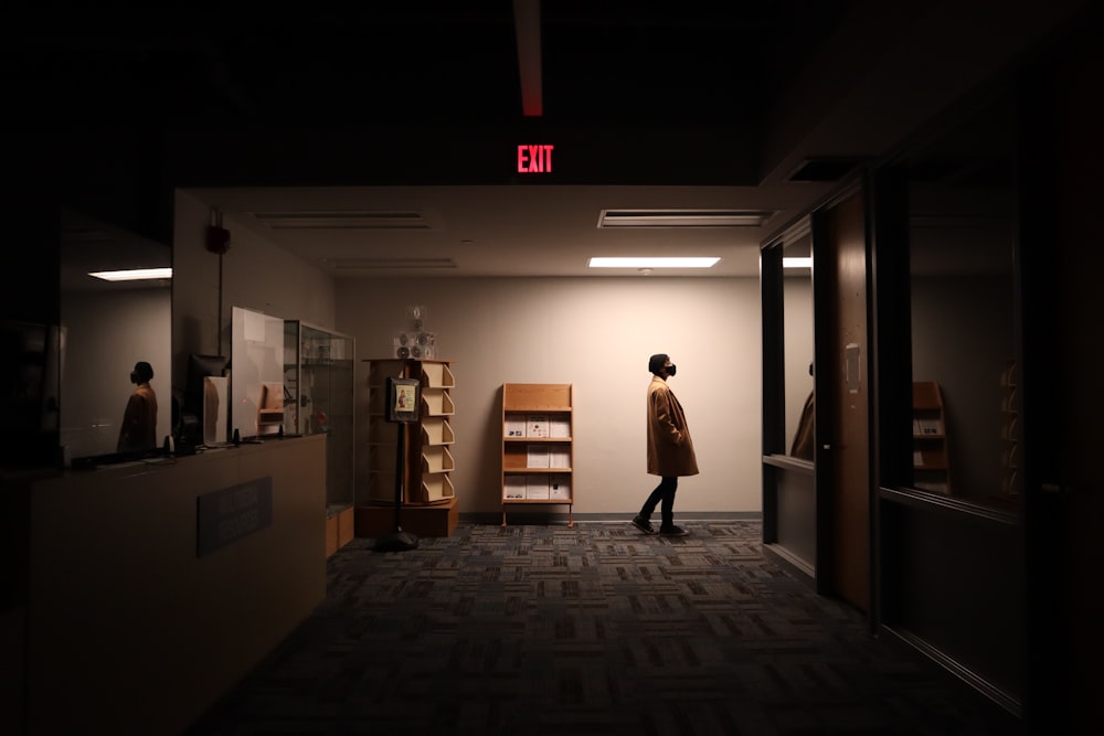 a person walking down a hallway in a dark room