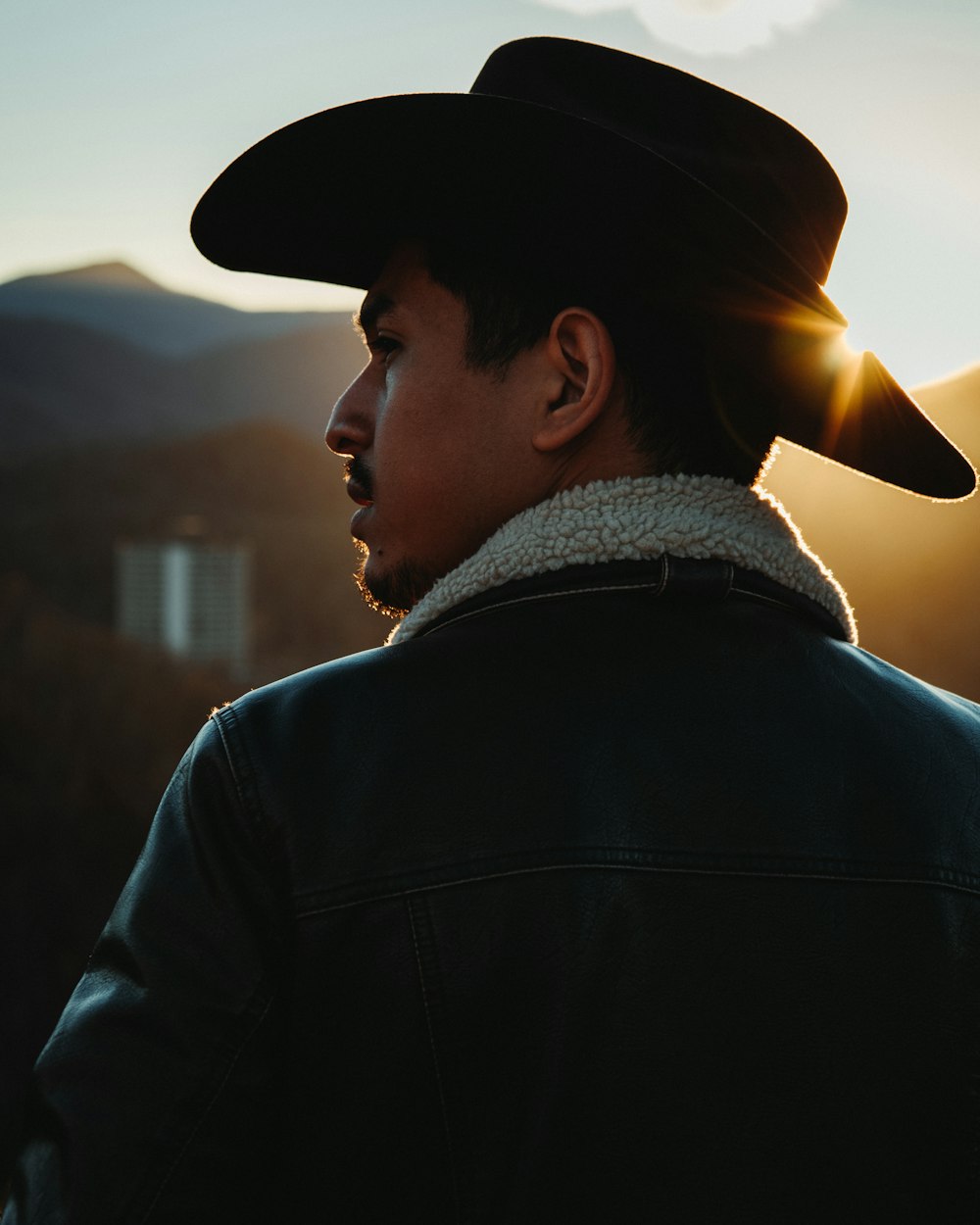 a man wearing a black hat and a black jacket