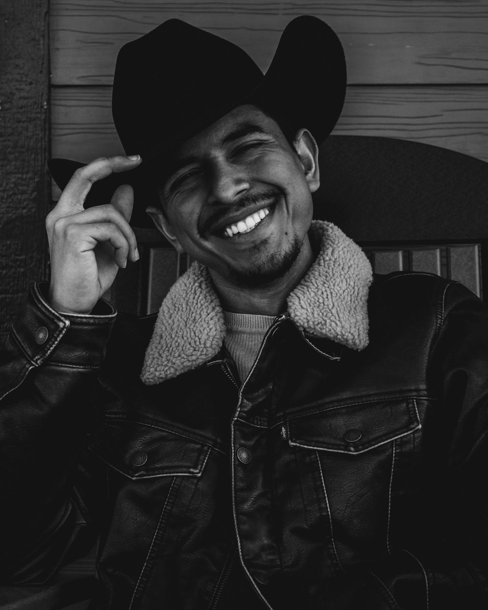 a black and white photo of a man wearing a cowboy hat