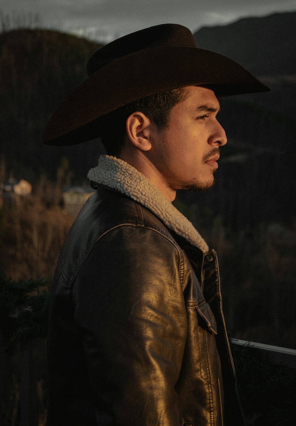 a man wearing a brown hat and a leather jacket