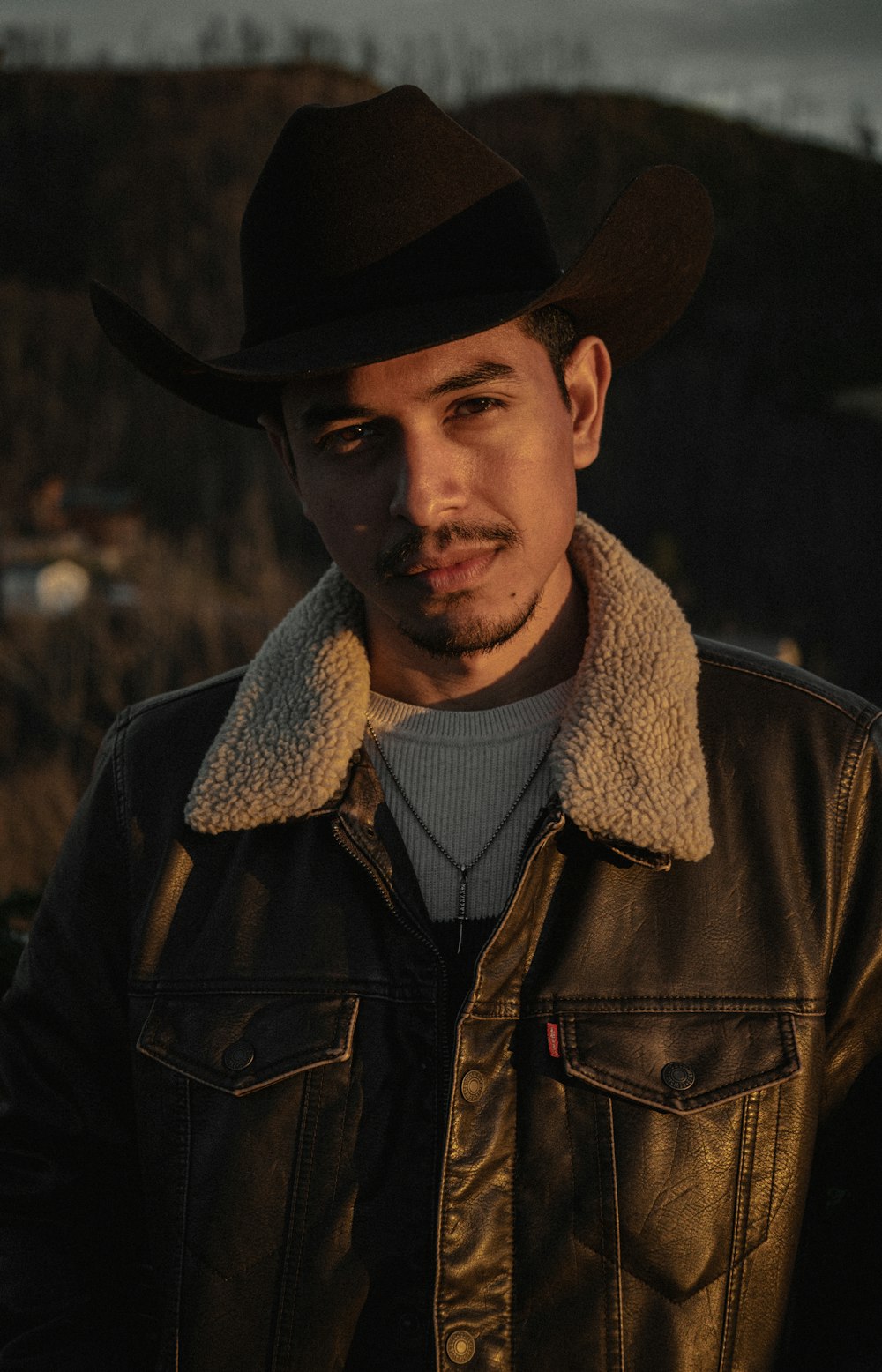 a man wearing a hat and a leather jacket