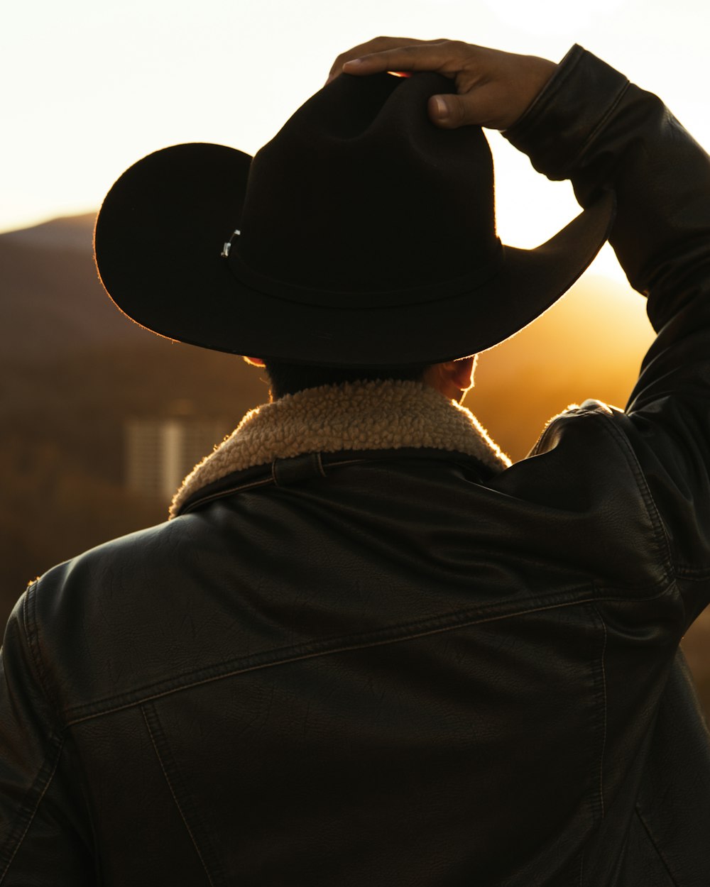 a person wearing a cowboy hat and jacket