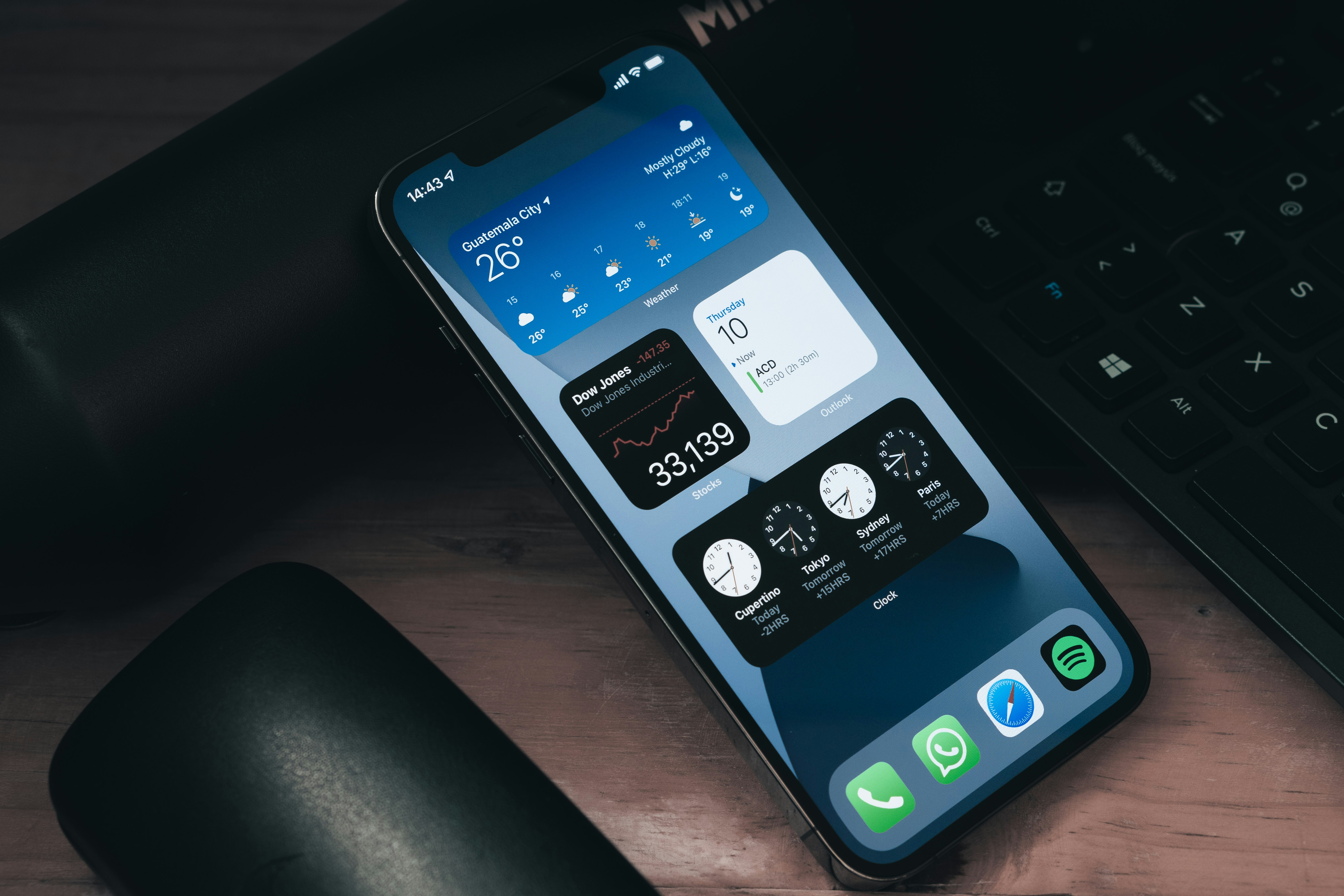 a cell phone sitting on top of a desk next to a keyboard