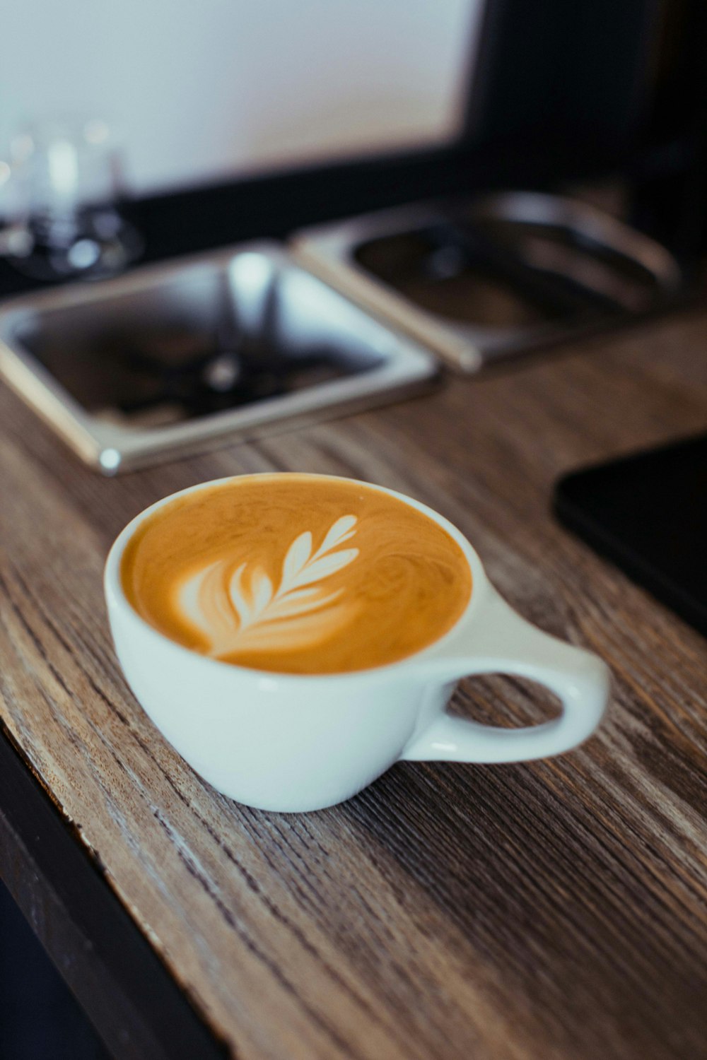 a cup of latte art on a wooden table