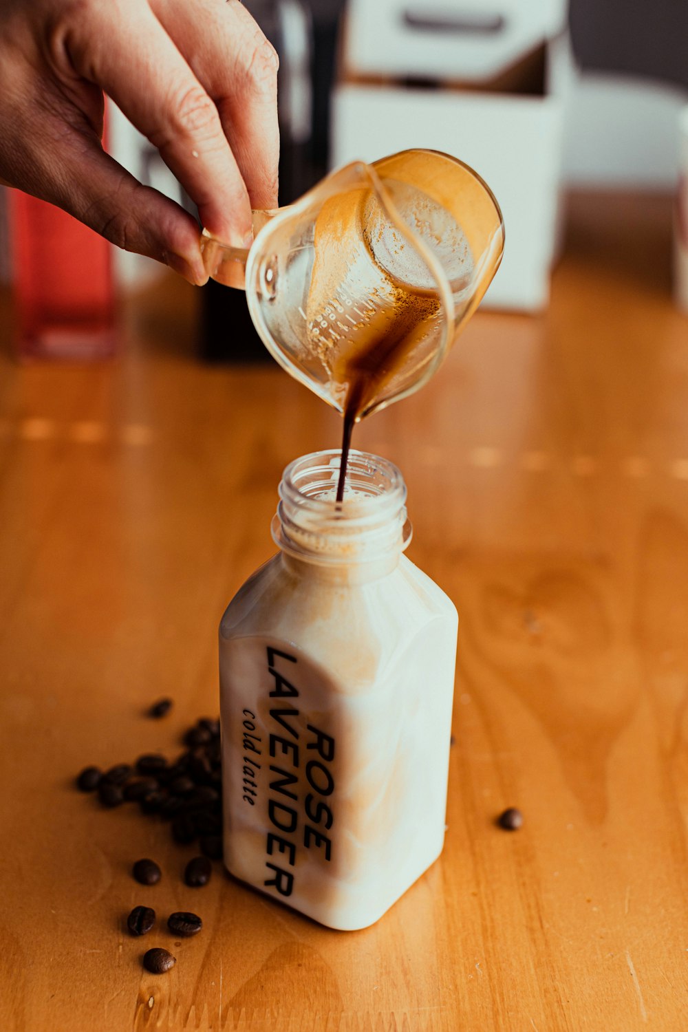 a person pouring coffee into a glass jar