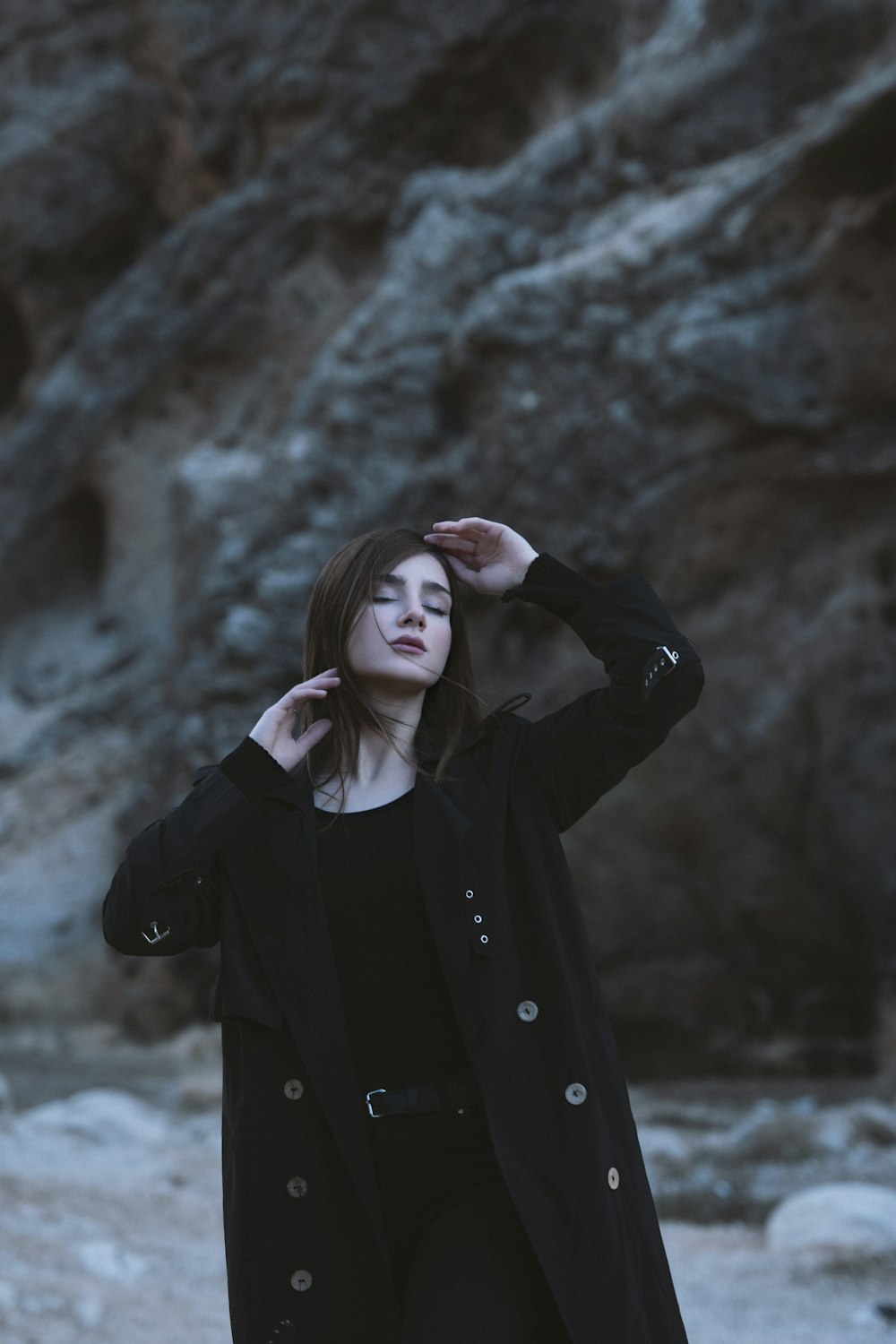 a woman standing in front of a rocky mountain