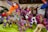 A collection of brightly colored, intricately embroidered stuffed animal toys with various designs including unicorns and llamas. Each toy features vibrant patterns and multicolored threads, creating a festive and artistic display.