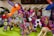 A collection of brightly colored, intricately embroidered stuffed animal toys with various designs including unicorns and llamas. Each toy features vibrant patterns and multicolored threads, creating a festive and artistic display.