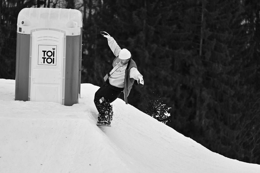 a man riding a snowboard down the side of a snow covered slope