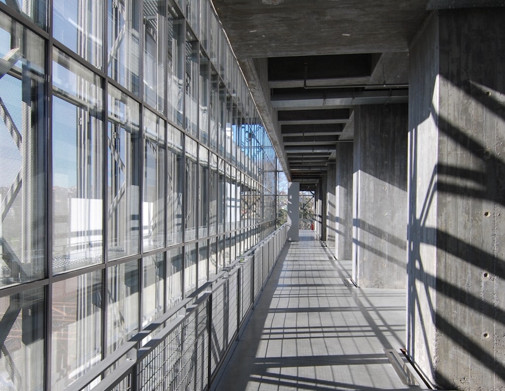a long walkway lined with windows next to a building