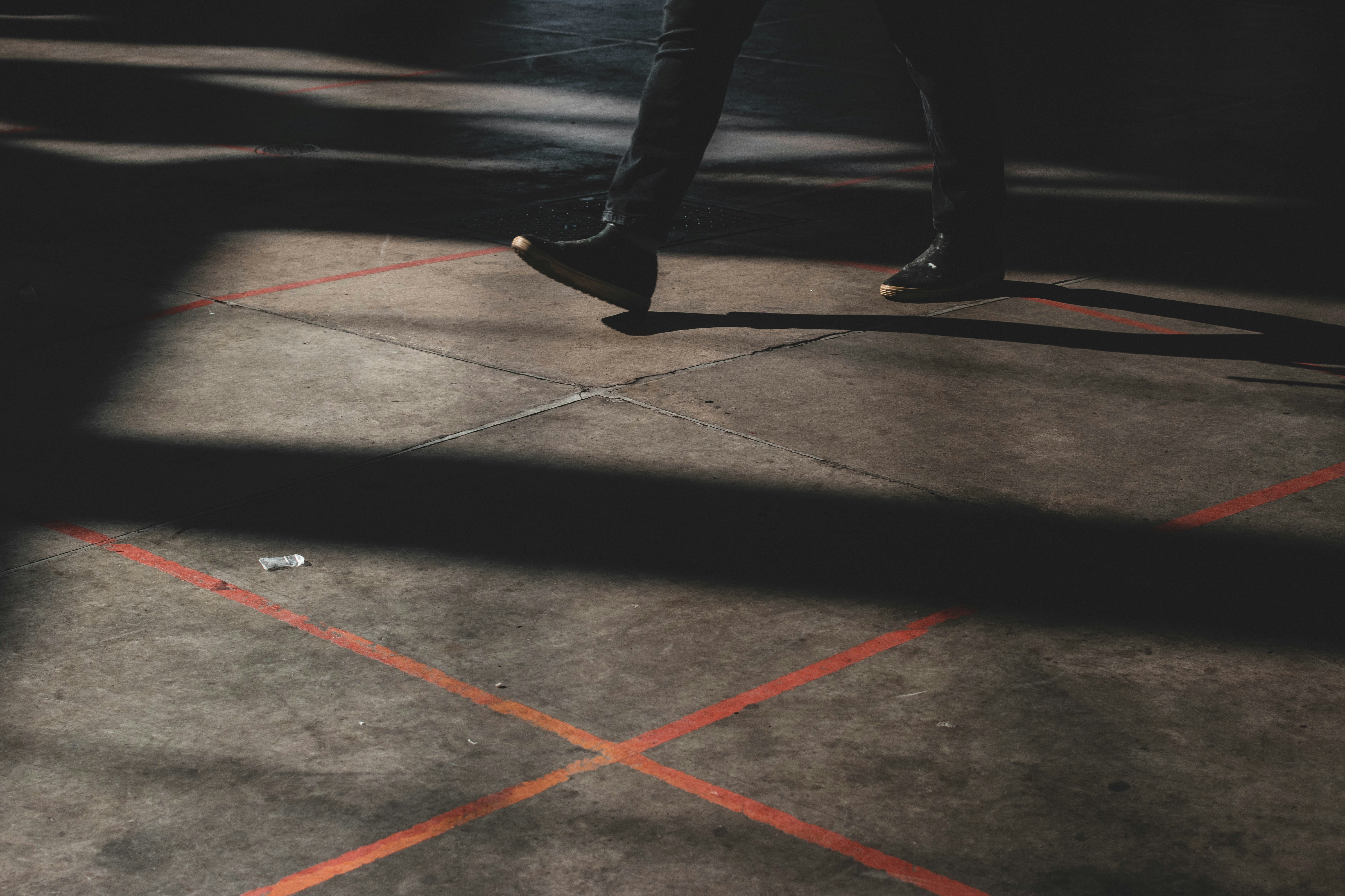 a person standing on a sidewalk with a skateboard