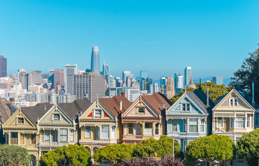 a row of houses in front of a city skyline